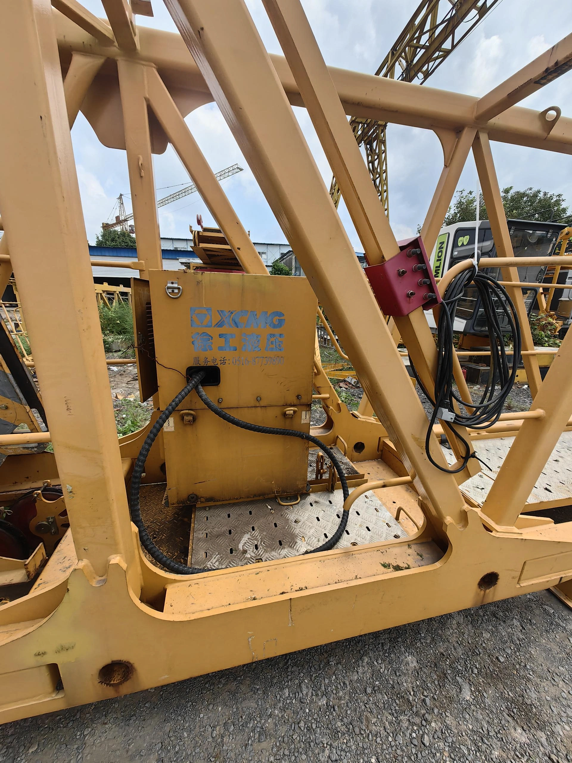 Componente amarillo de grúa con armario de control y tambor de cable